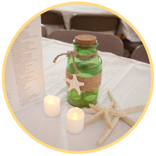 Green bottle and electric candles on a white tablecloth