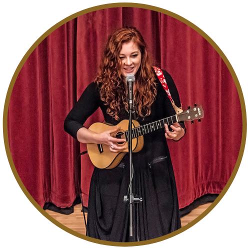 Mandy Harvey singing and playing acoustic guitar onstage in Reading
