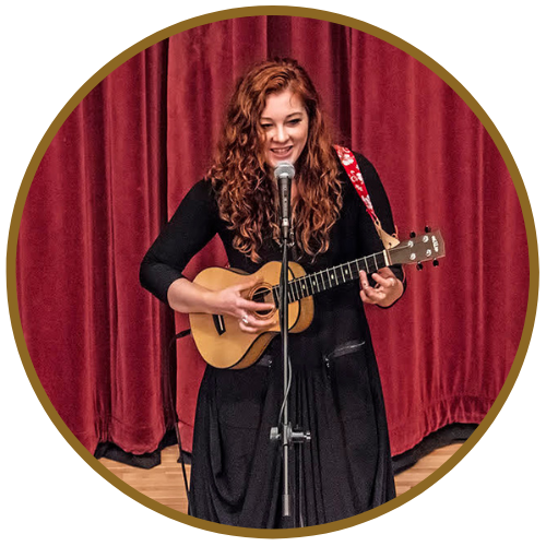 Speakers Mandy Harvey singing and playing acoustic guitar onstage in Reading