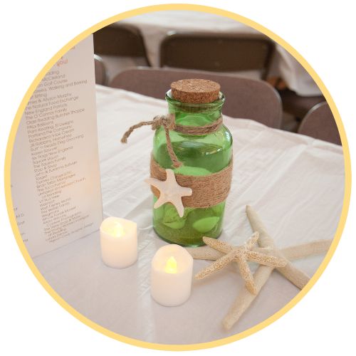 Green bottle and electric candles on a white tablecloth