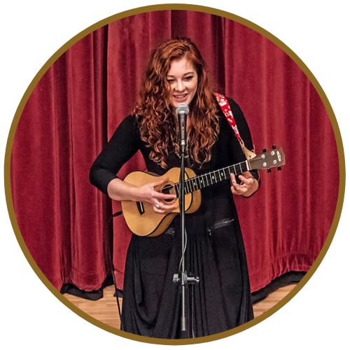 Mandy Harvey singing and playing acoustic guitar onstage in Reading